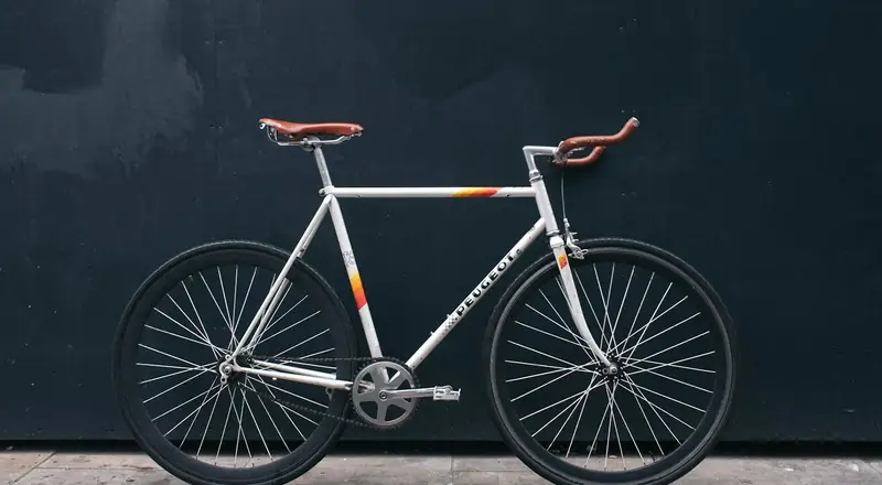 Bicicleta clássica apoiada em parede escura